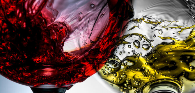 Red and white wine splash in wineglasses close-up macro.